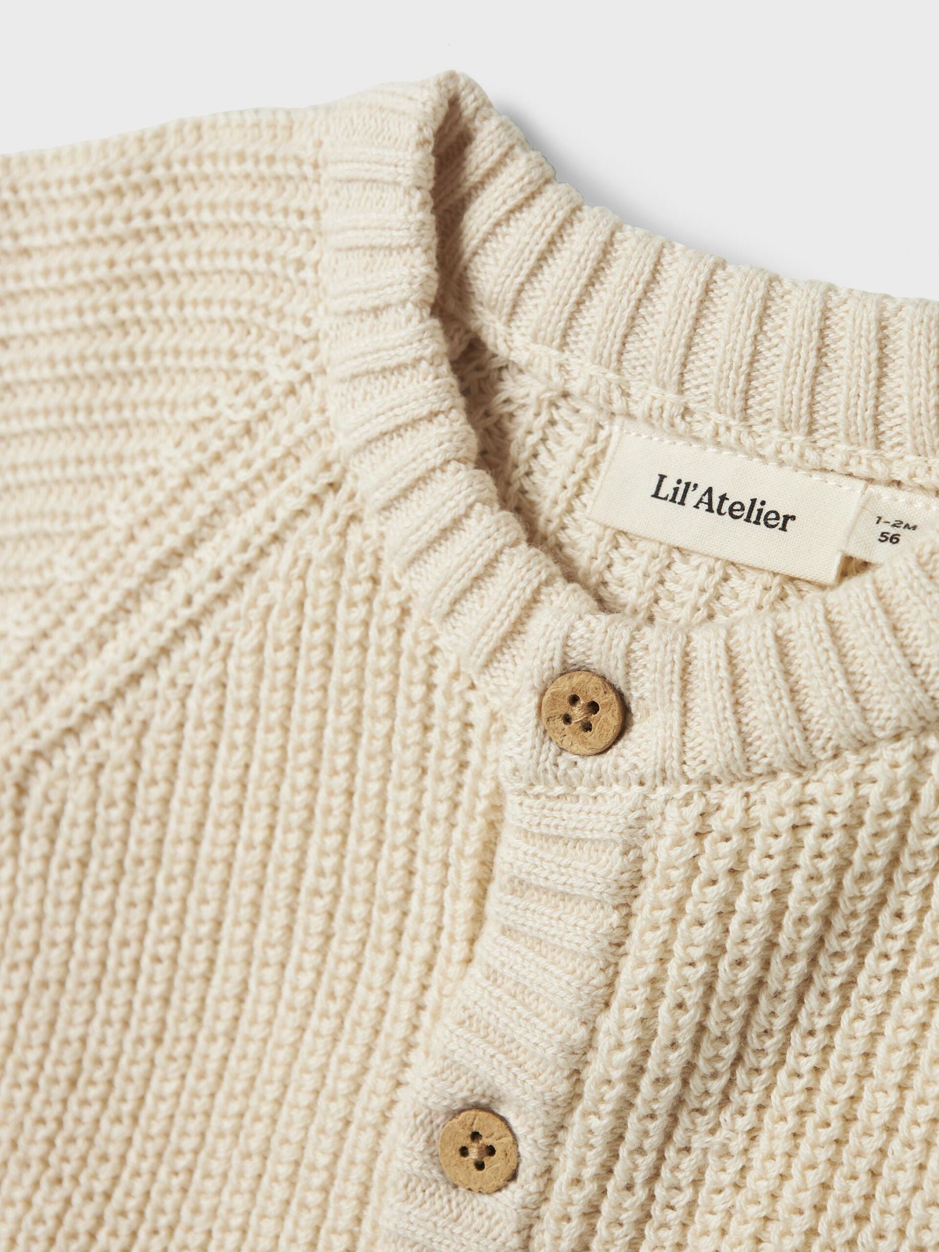 Nahaufnahme der Knopfleiste und Struktur der Baby-Strickjacke