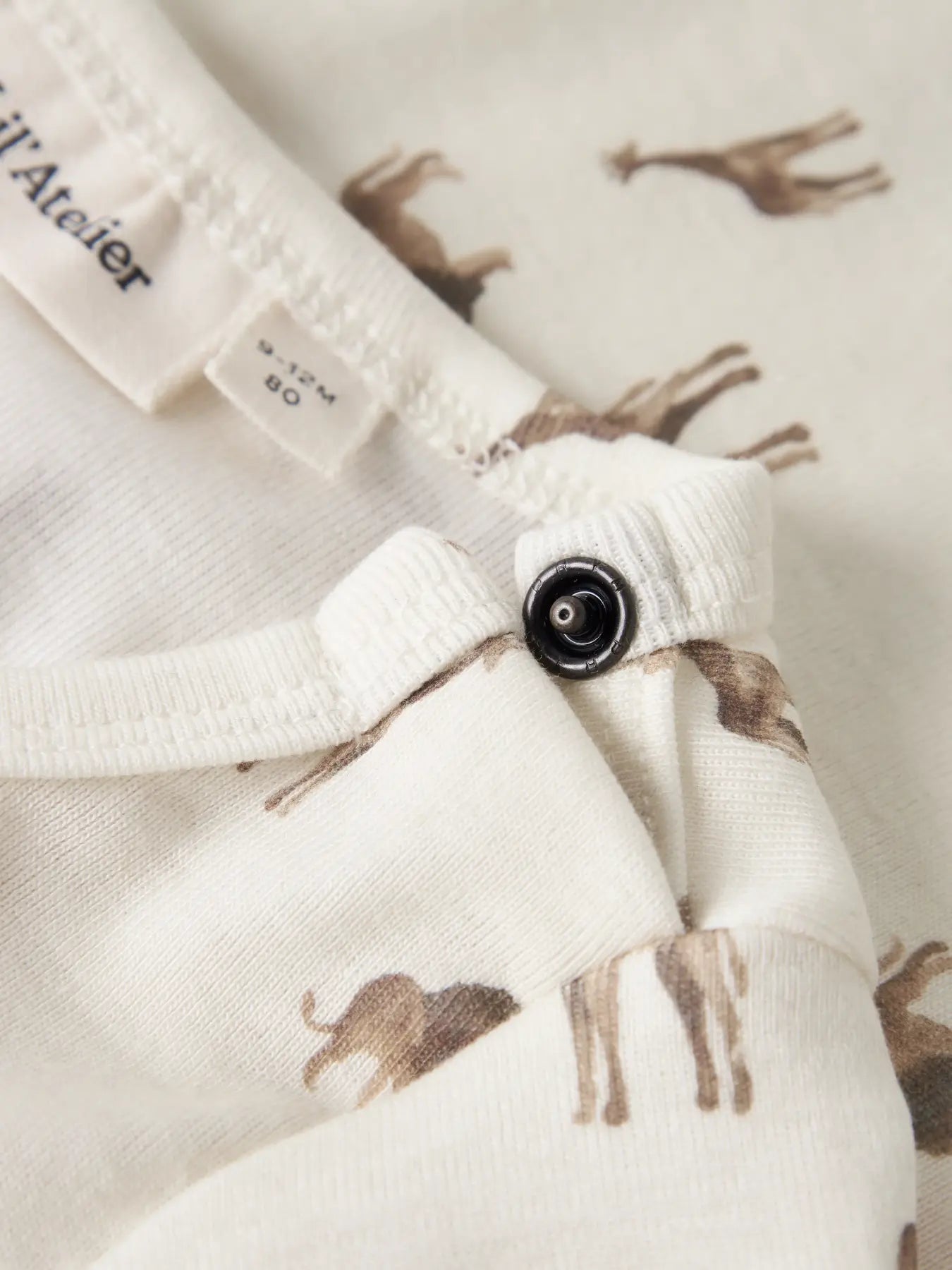 Detailansicht Giraffen- und Löwen-Print sowie Druckknöpfe am Babybody von Lil’ Atelier im Bärechind Winterthur Zürich Schweiz