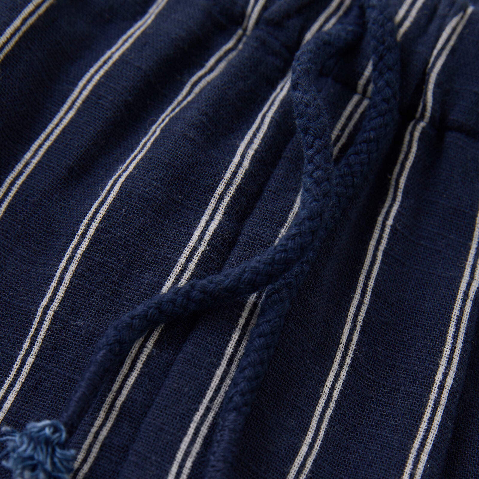 Nahaufnahme des weichen, atmungsaktiven Stoffes der dunkelblauen gestreiften Babyhose von Minymo