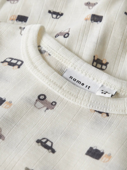 Detailaufnahme vom Babybody mit Auto-Muster aus Merinowolle in Naturweiss.