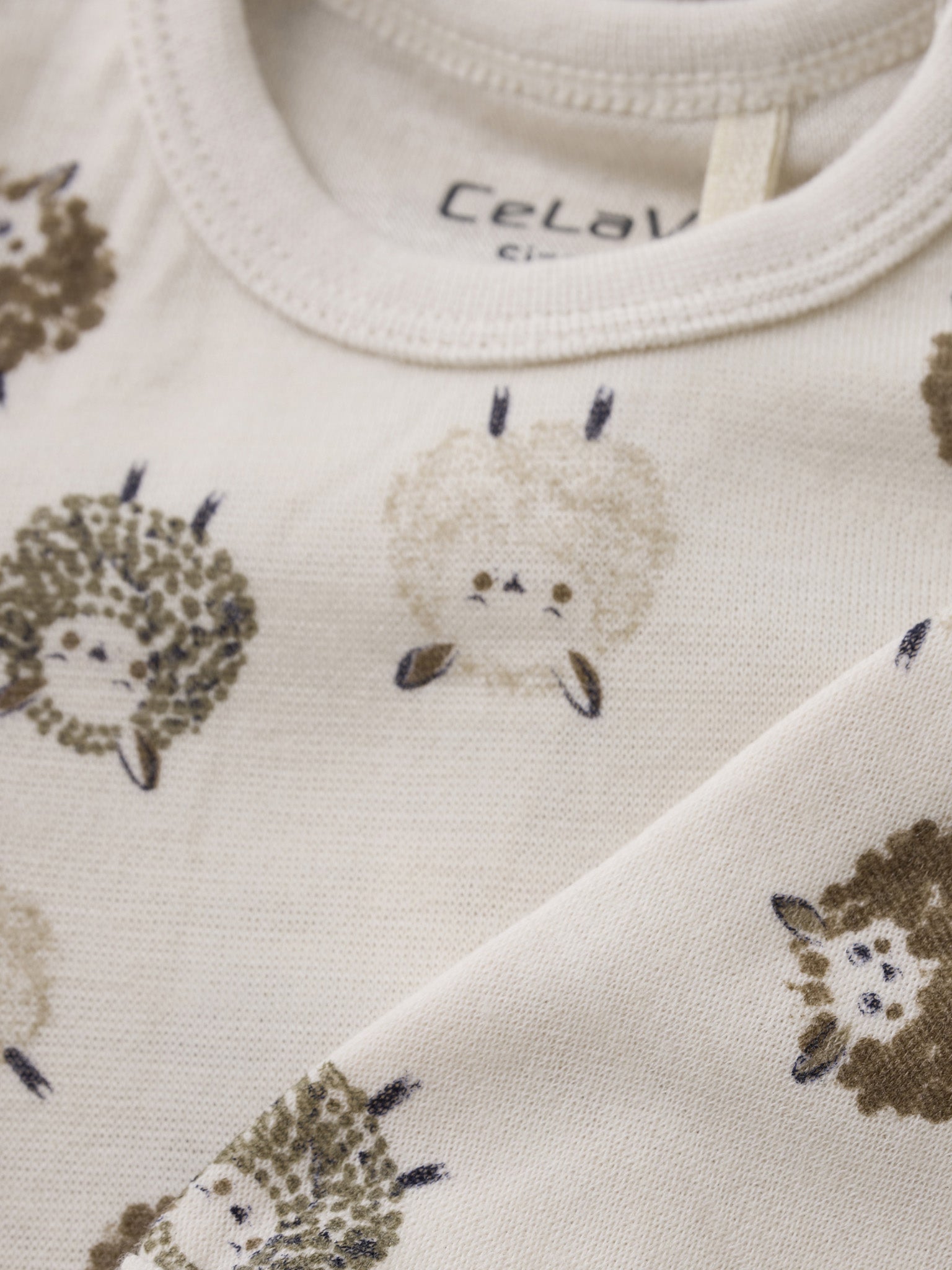 Stoffdetail mit niedlichen Schafen auf dem CeLaVi Langarmbody – im Bärechind in Winterthur, Zürich, Schweiz