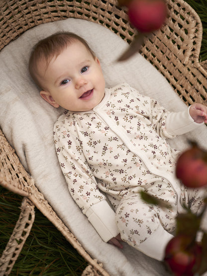 Baby trägt CeLaVi Jumpsuit mit Blumenmuster – erhältlich im Bärechind in Winterthur, Zürich, Schweiz.