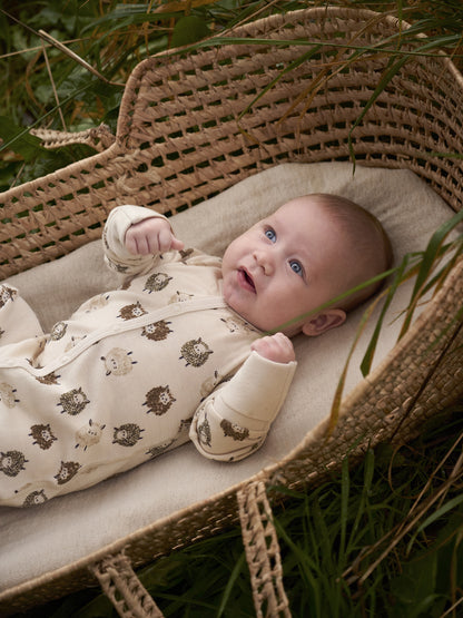 Baby trägt CeLaVi Jumpsuit mit Schafen im Korb – erhältlich im Bärechind in Winterthur, Zürich, Schweiz.