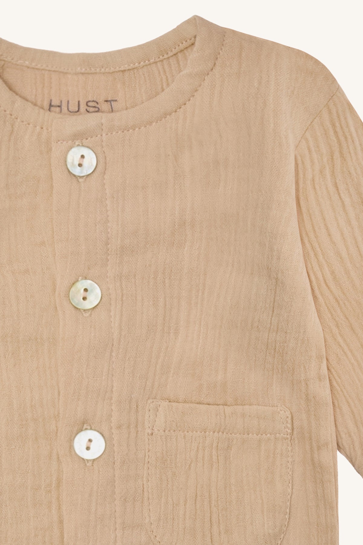 Detailaufnahme der Chai Jacke Cuban sand – feine Struktur aus gewebter Bio-Baumwolle und praktische Tasche, erhältlich in Winterthur, Zürich, Schweiz.