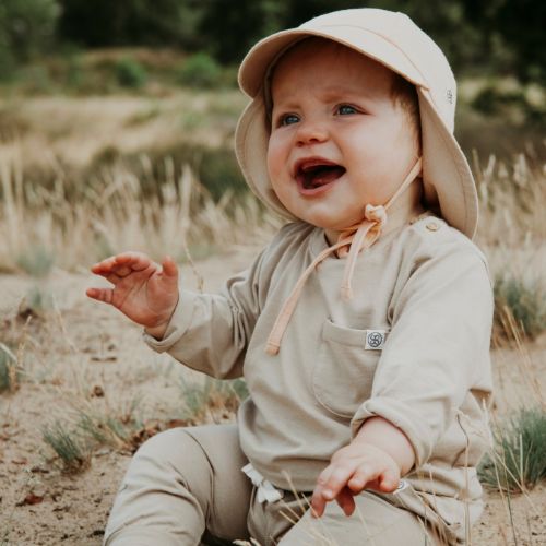 Baby trägt Cloby UV-Sonnenhut in Peanut – Weicher, atmungsaktiver Sonnenhut mit UPF 50+ Schutz für empfindliche Babyhaut. Perfekt für sonnige Tage. Jetzt in Winterthur, Zürich, Schweiz erhältlich.