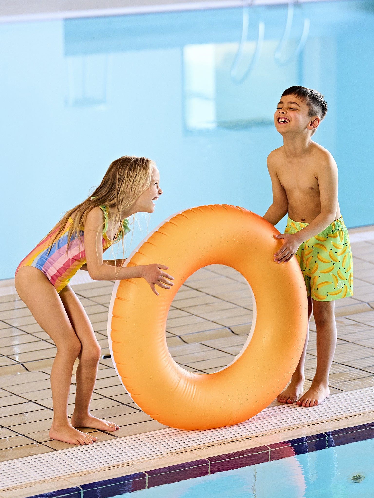 Kind trägt Color Kids Badeanzug Regenbogen im Pool Sommer Kinderkleidung Schweiz