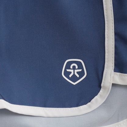 Detailaufnahme der Color Kids Badeshorts in Uni Blau – Logo und weisser Saum