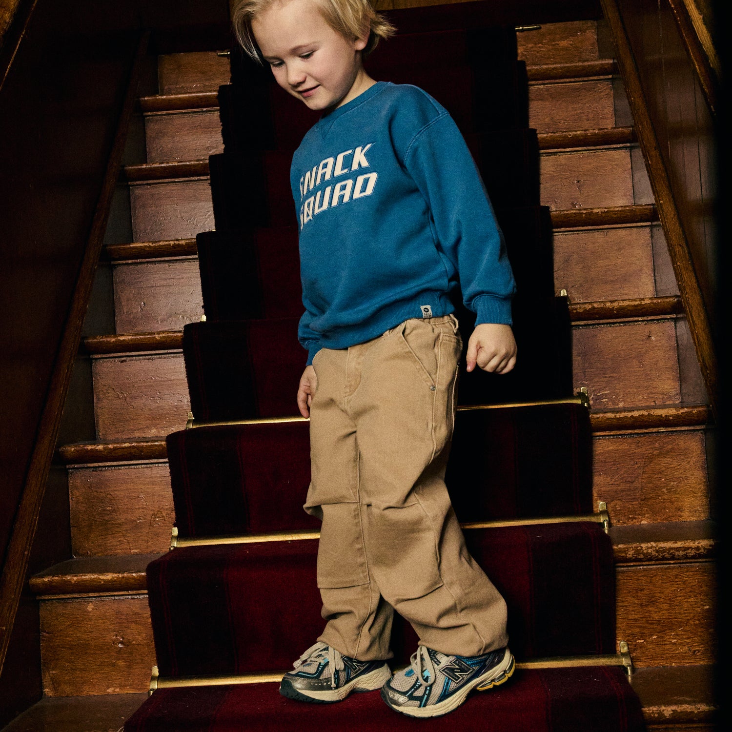 Kind trägt das blaue Daily Seven Sweatshirt mit Snack Squad Print