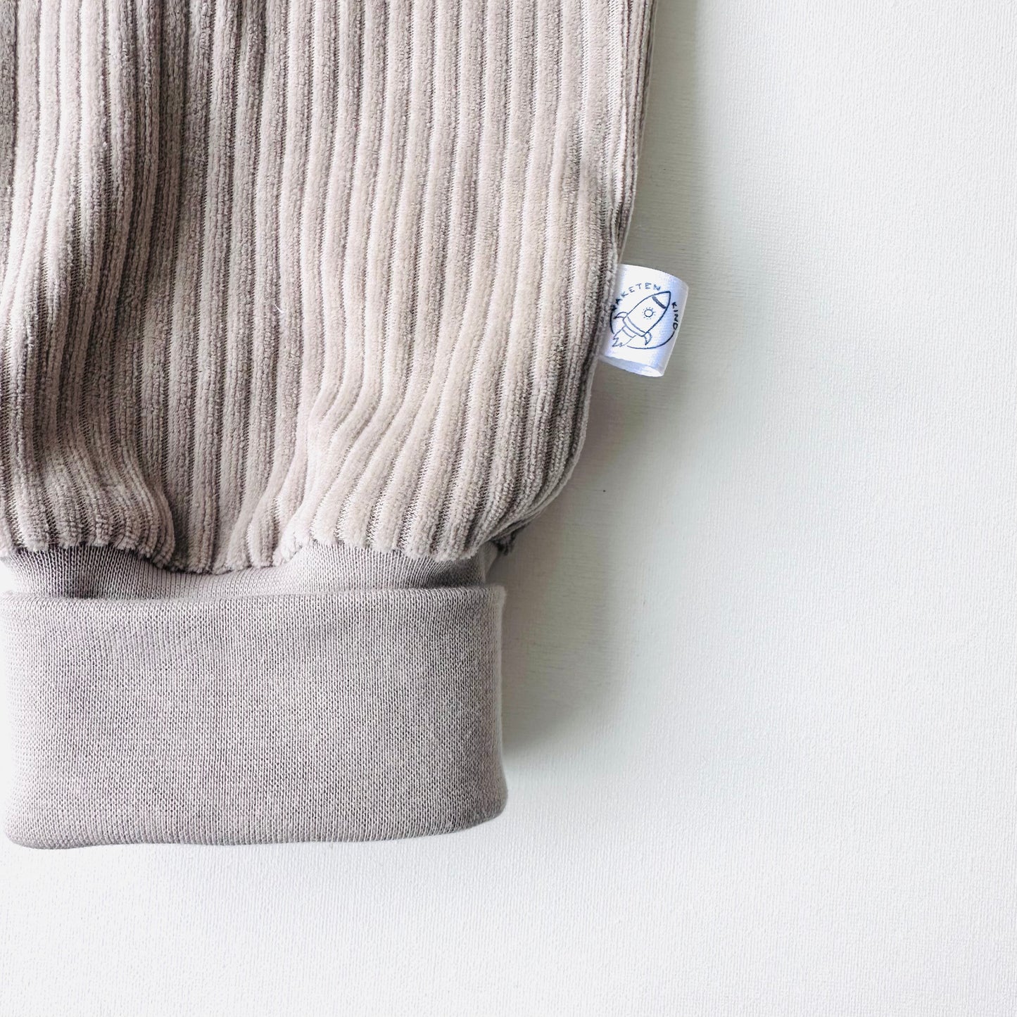 Detailaufnahme der Beinbündchen der Cordnicky-Hose Steingrau, handgemacht von Raketenkind, erhältlich im Bärechind in Winterthur, Zürich Schweiz.