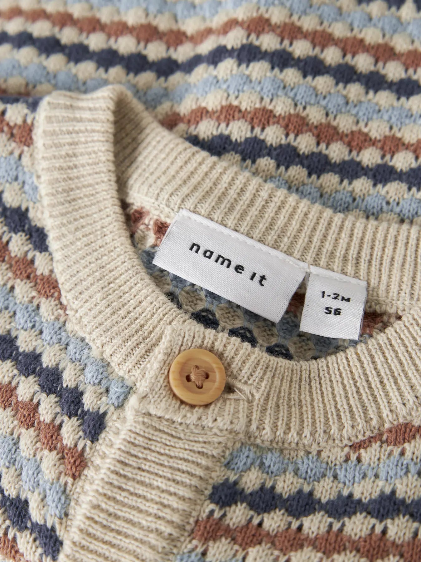 Detailaufnahme Streifenmuster und Knöpfe bei Baby Strickcardigan, erhältlich bei Bärechind Winterthur Zürich Schweiz.