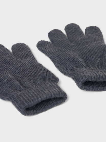 Nahaufnahme von Bündchen und Strickstruktur eines dunkelblauen Wollhandschuhe.

