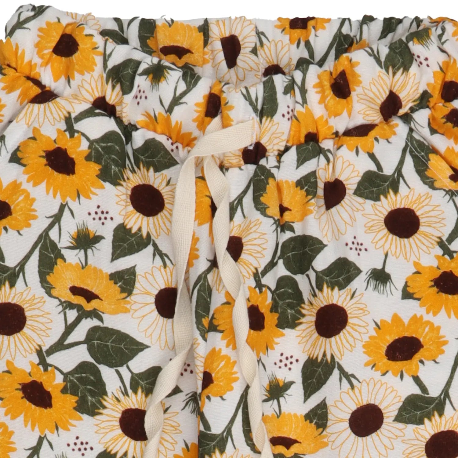 Detailaufnahme einer nachhaltigen Muslin-Kinderhose mit farbenfrohem Sonnenblumenmuster.