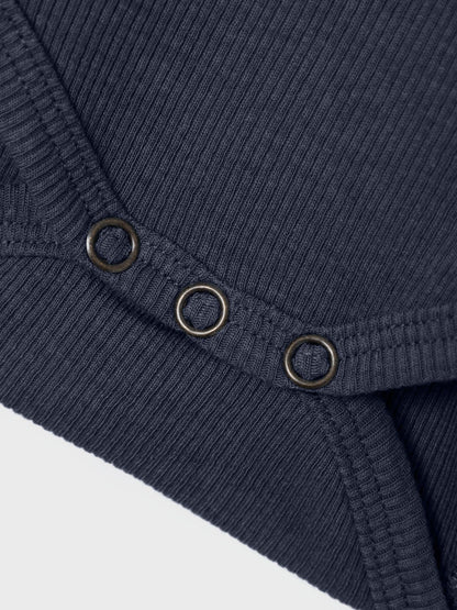 Alt-Text: Detailaufnahme des Bio-Baumwoll-Bodys in Indigo Melange. Nachhaltig bei Bärechind in Winterthur, Zürich Schweiz erhältlich