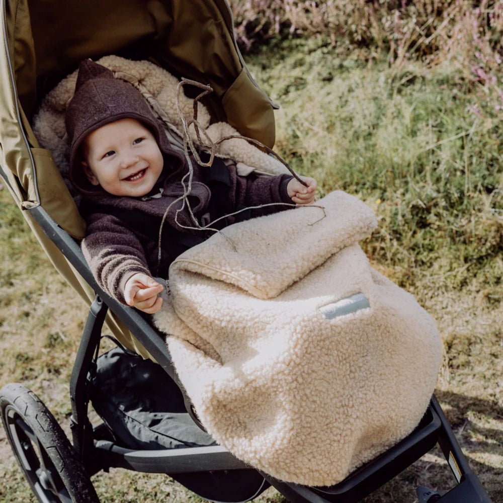 Baby im Emma & Noah Merino Kinderwagenfusssack aus Wolle