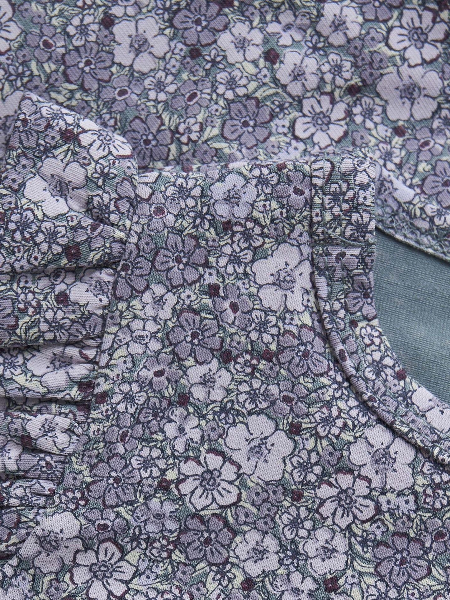 Detailaufnahme Blumenprint auf Fixoni Langarmbody in Lila – erhältlich im Bärechind in Winterthur, Zürich, Schweiz