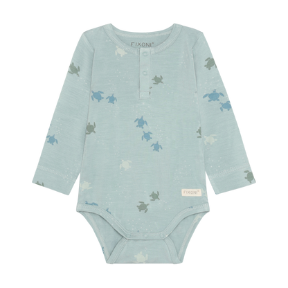 Baby trägt Fixoni Bambus Body mit Schildkröten Print aus dem Kinderladen Bärechind Winterthur Zürich Schweiz für nachhaltige Kinderkleider.