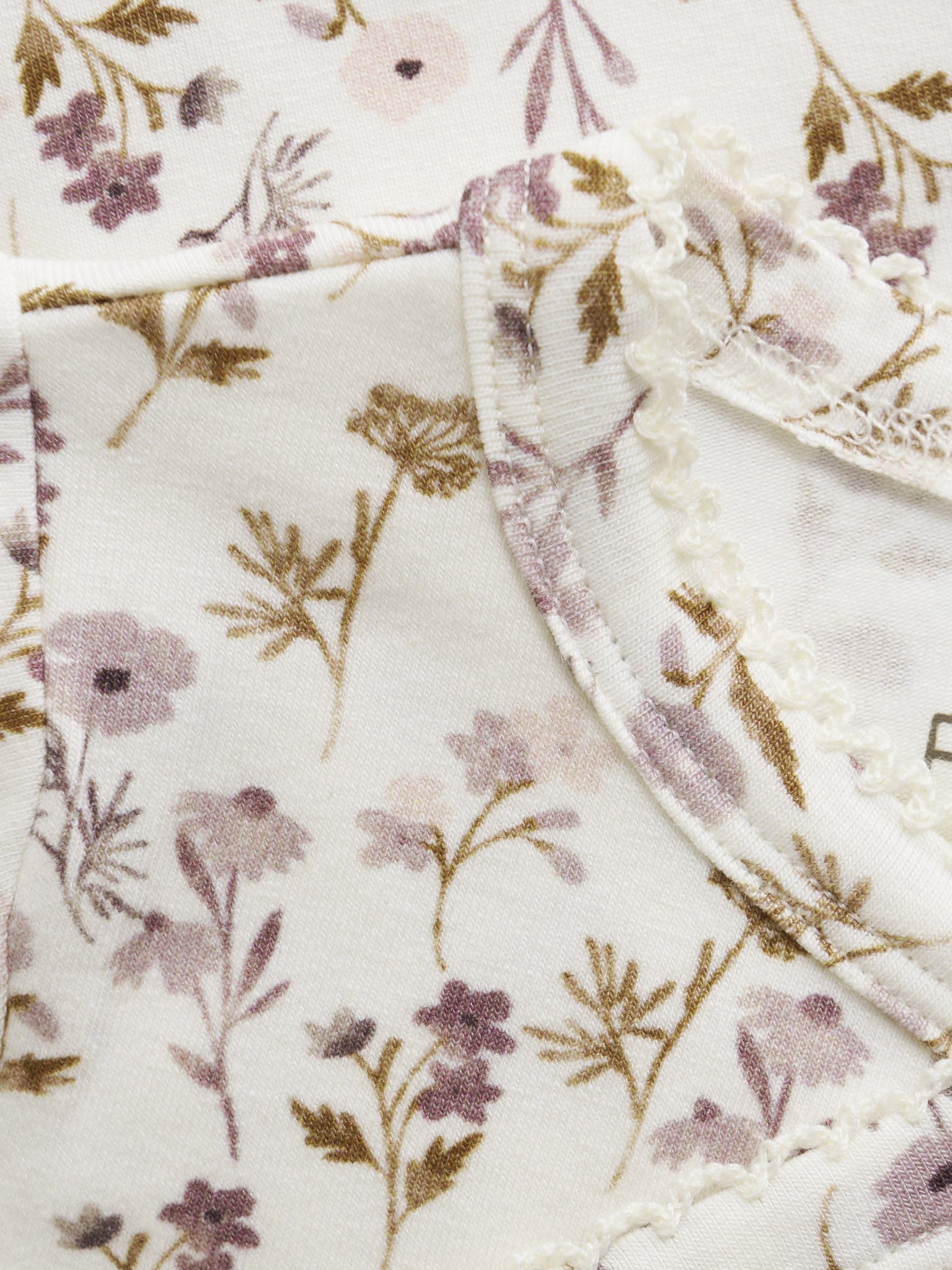 Nahaufnahme des zarten Blumenprints von Fixoni Wickelbody – erhältlich im Bärechind in Winterthur, Zürich, Schweiz