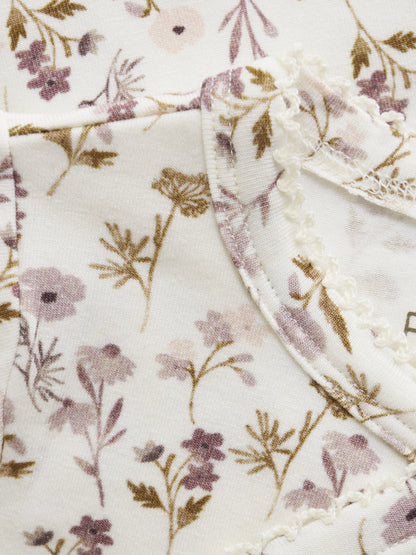 Nahaufnahme des zarten Blumenprints von Fixoni Wickelbody – erhältlich im Bärechind in Winterthur, Zürich, Schweiz