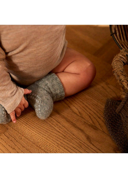 Detailaufnahme von Babyfüssen in Alpakasocken – warm, rutschfest und ideal für Wintertage