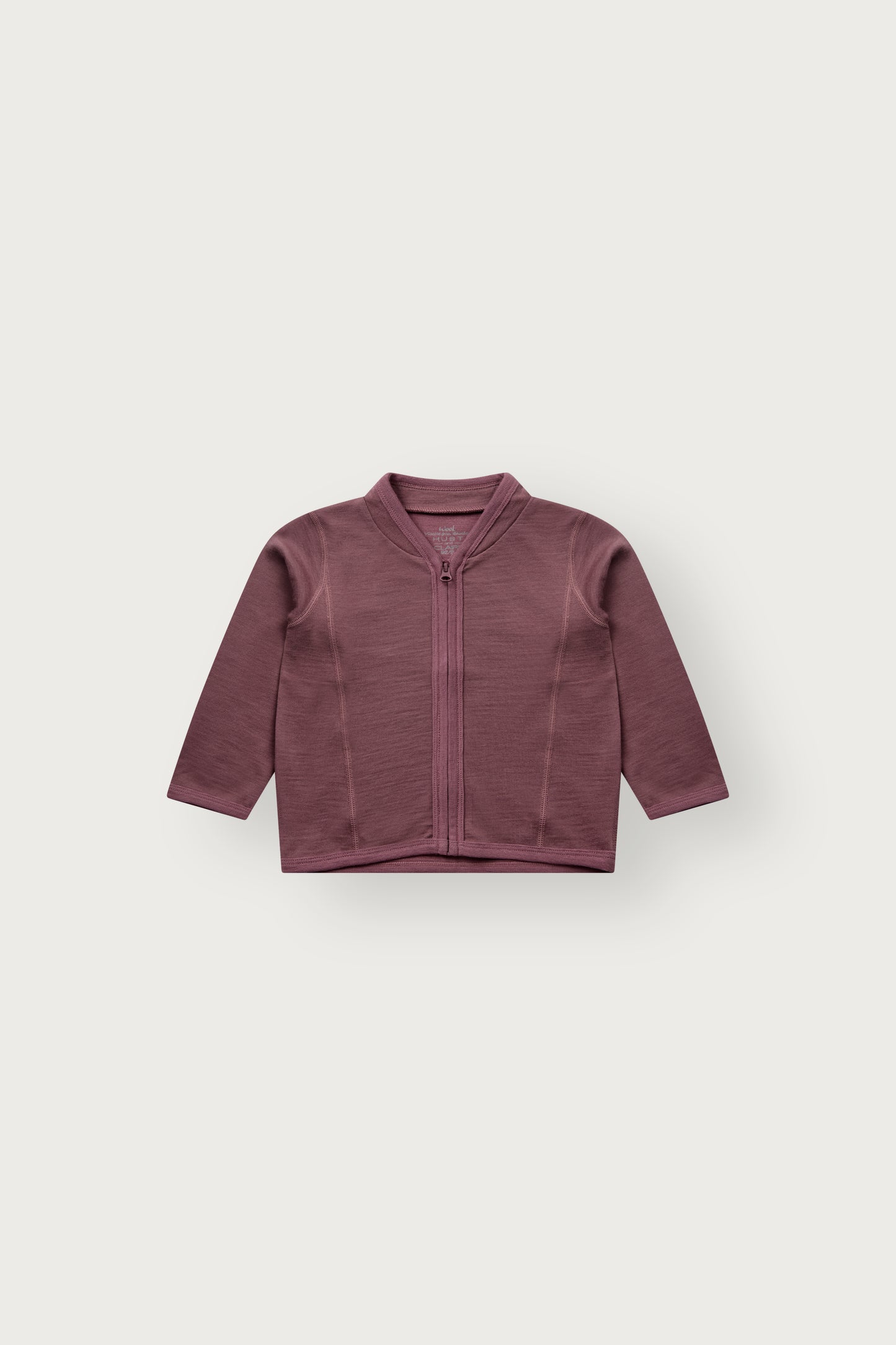 Baby trägt die Camil Wolljacke von Hust & Claire in Old Rose mit offenem Reissverschluss