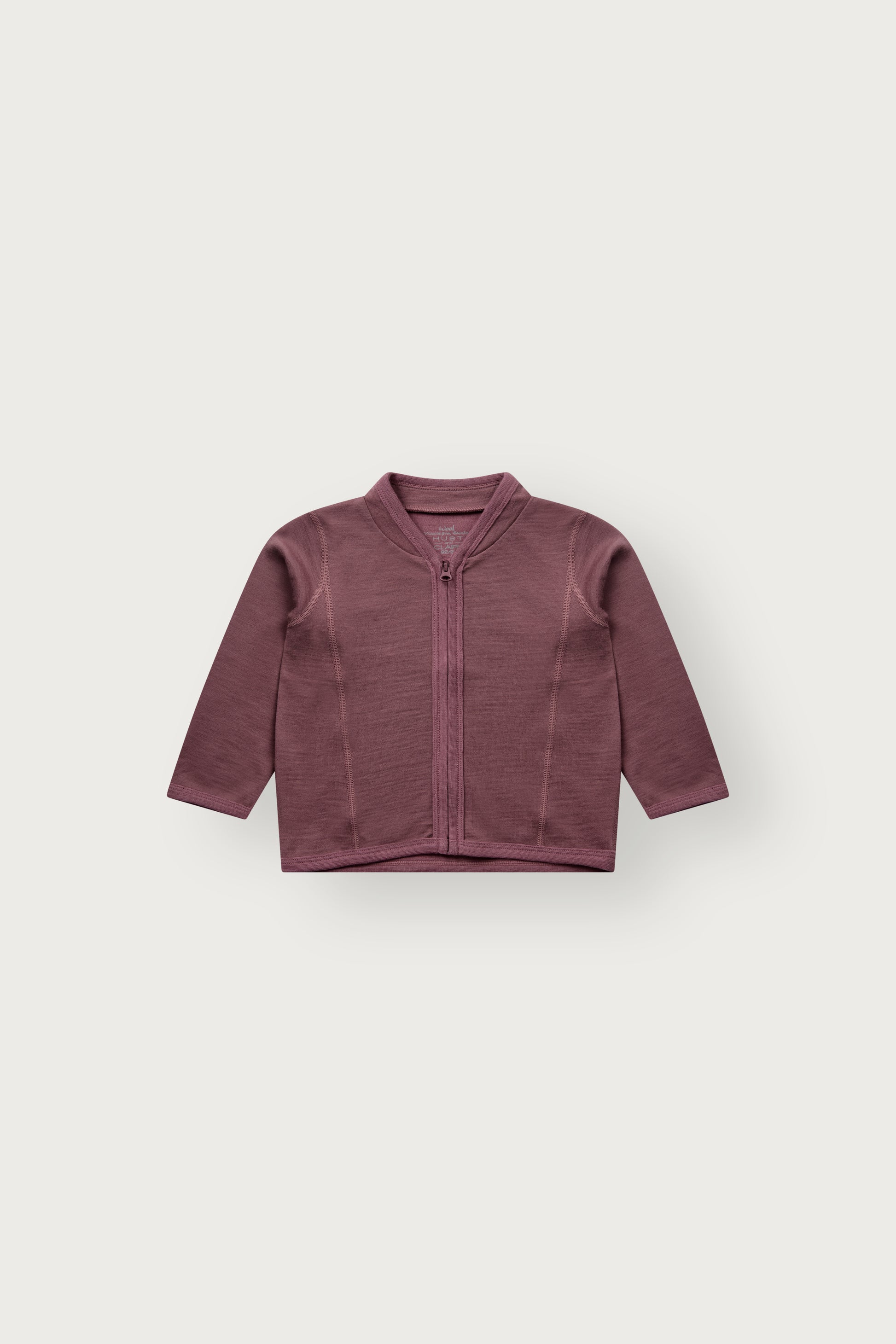 Baby trägt die Camil Wolljacke von Hust & Claire in Old Rose mit offenem Reissverschluss