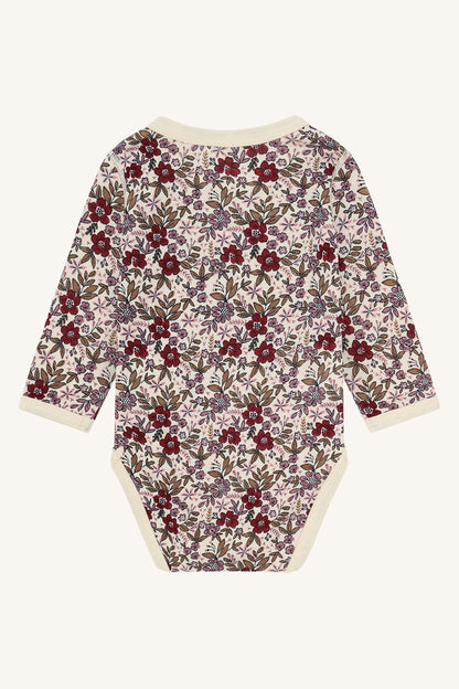 Rückansicht Hust&Claire Baloo Body aus Wolle/Bambus mit Blumenmuster – erhältlich im Bärechind Winterthur, Zürich, Schweiz.