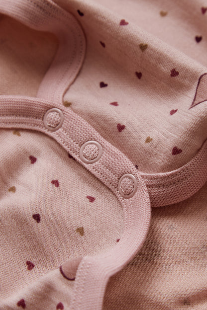 Nahaufnahme der Druckknöpfe und Herzchenprint auf dem Baloo Body in Dusty Rose