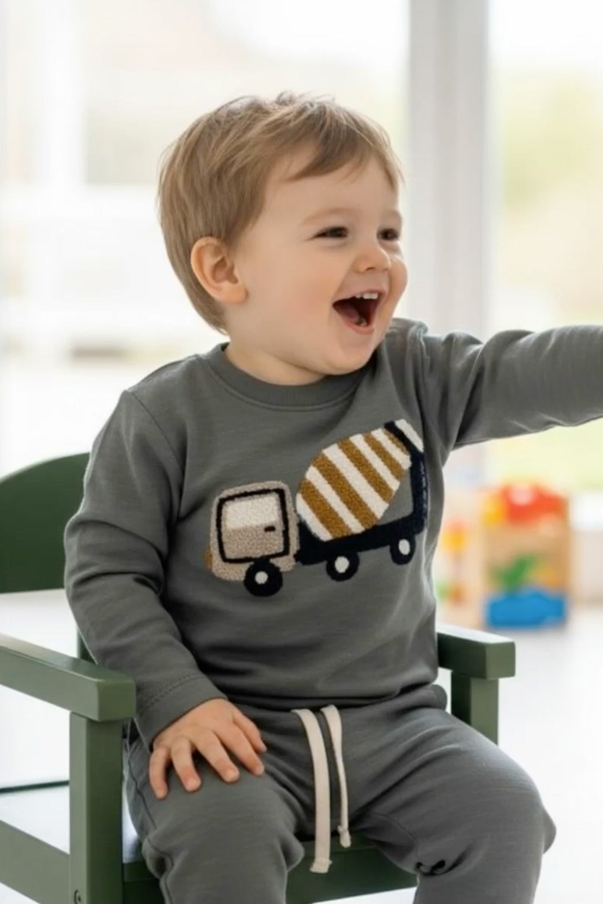 Kleiner Junge trägt das Hust&Claire Sejer Langarmshirt mit Betonmischer-Motiv in Balsam Green