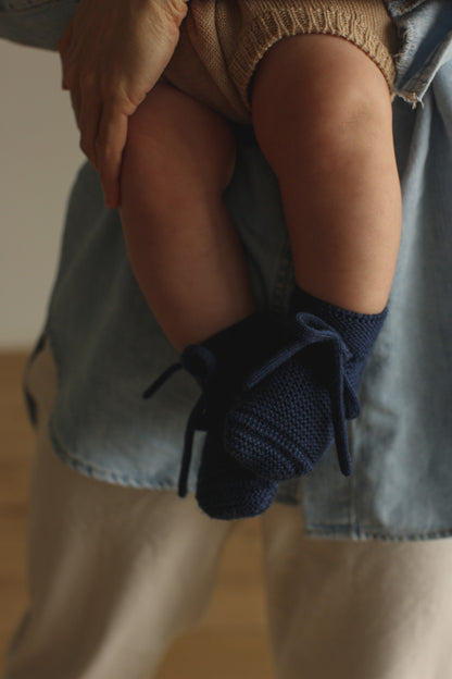 Baby trägt die Hvid Strickschuhe Booties in Blau, erhältlich bei Bärechind