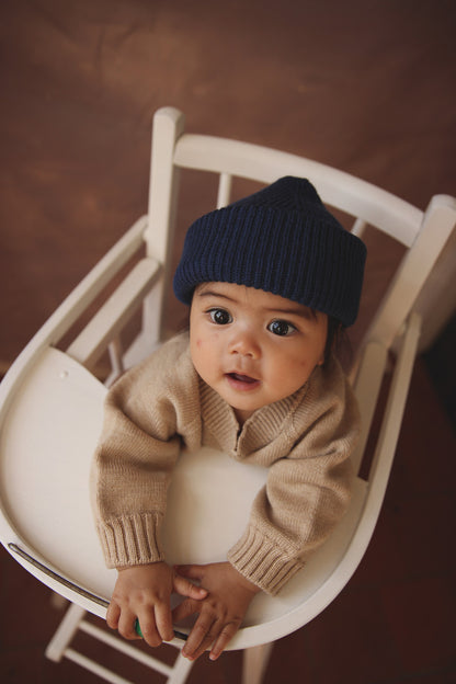 Baby trägt Hvid Fonzie Beanie in Blue aus Merinowolle, erhältlich im Bärechind in Winterthur, Zürich Schweiz.