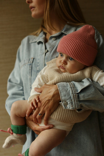 Baby trägt Hvid Fonzie Beanie in Bubblegum aus Merinowolle, erhältlich im Bärechind in Winterthur, Zürich Schweiz.