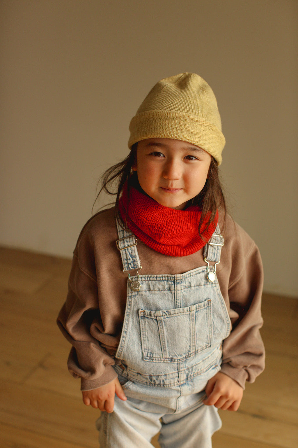 Kind trägt Hvid Gigi Loop Schal in Red, gestrickt aus Merinowolle, erhältlich im Bärechind in Winterthur, Zürich Schweiz.