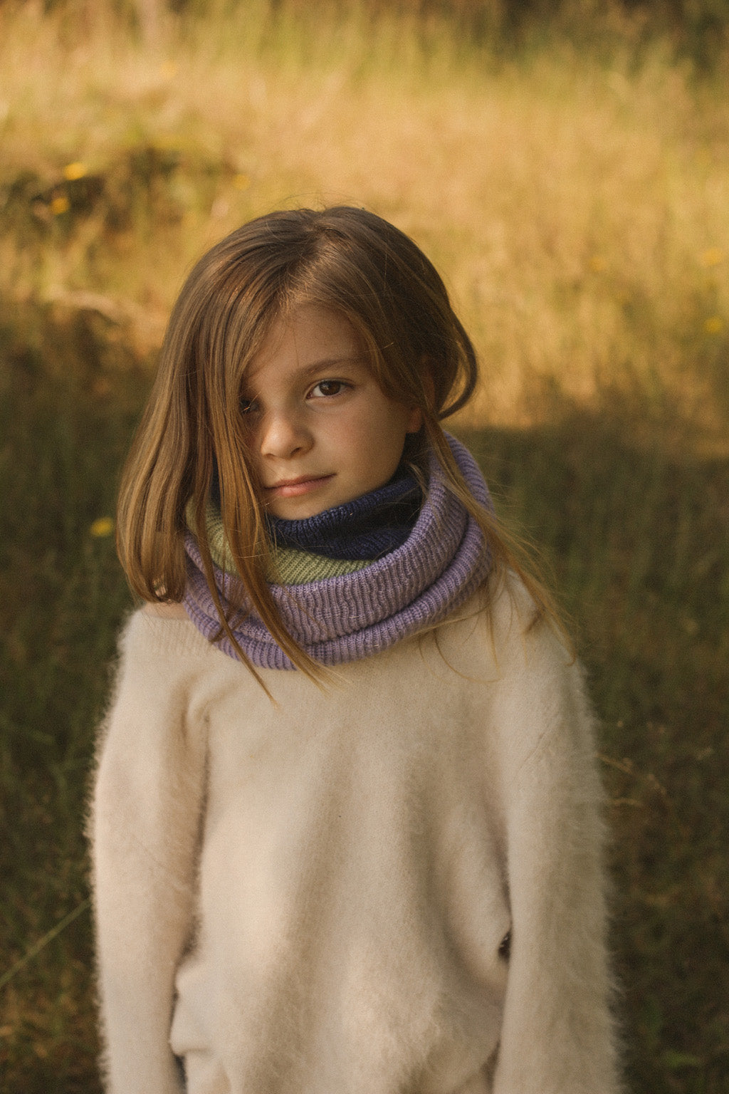 Kind trägt den Hvid Gigi Loop Schal in Lilac aus Merinowolle, erhältlich bei Bärechind