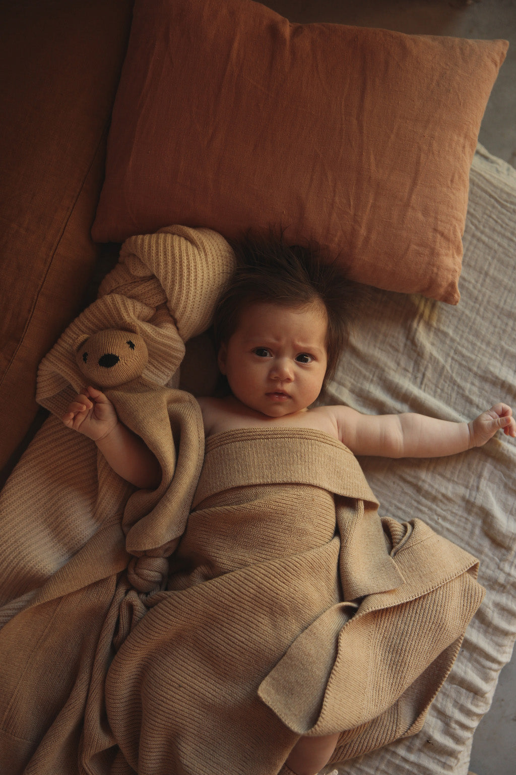 Baby eingekuschelt in Hvid Merino Babydecke Gust in Sand, erhältlich im Bärechind in Winterthur, Zürich Schweiz.