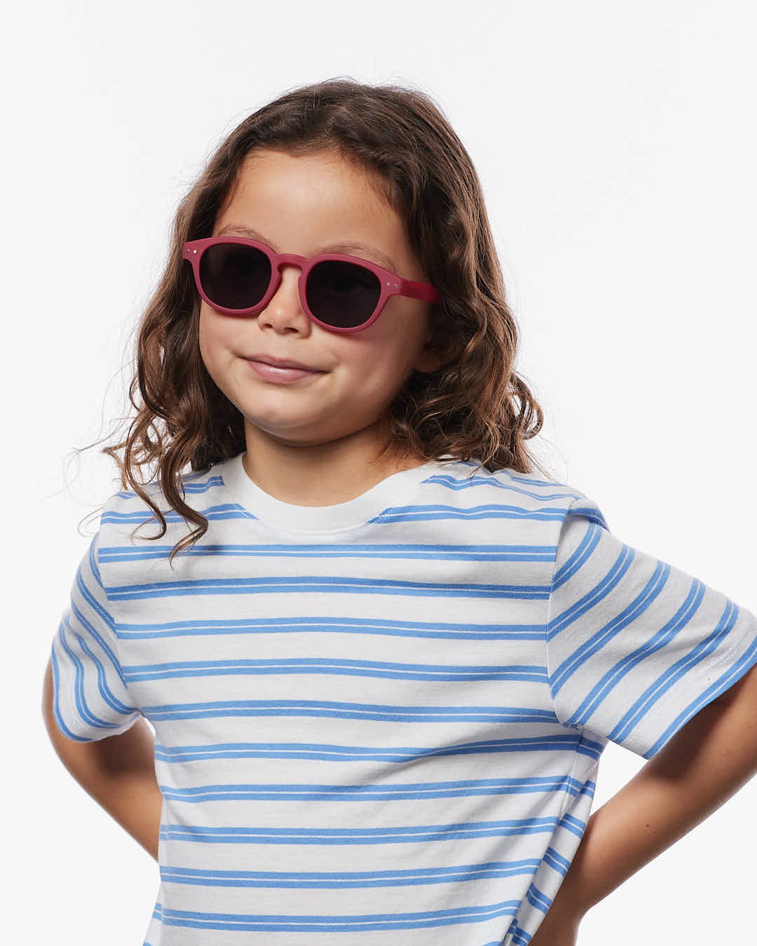 Kind trägt die IZIPIZI Kindersonnenbrille in Cranberry