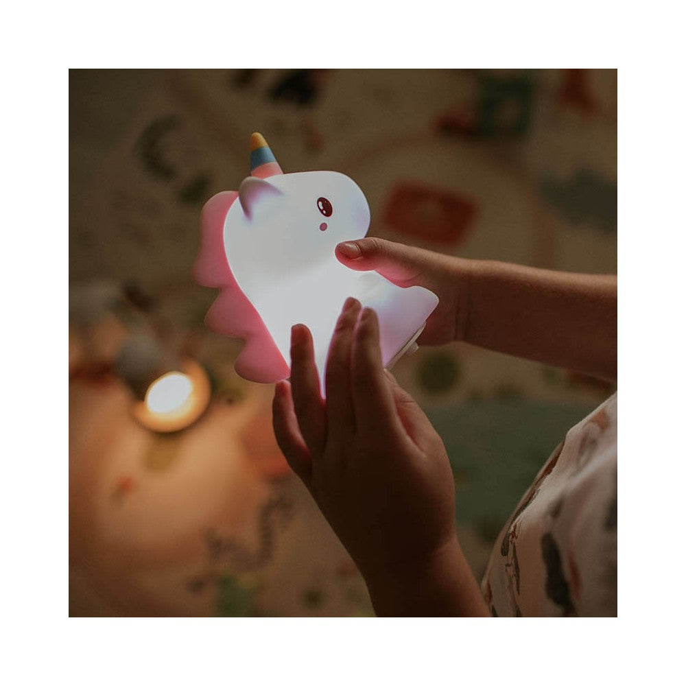 Kind hält leuchtende Einhornlampe, sanftes LED-Licht im Kinderzimmer, erhältlich im Bärechind Winterthur Zürich Schweiz.