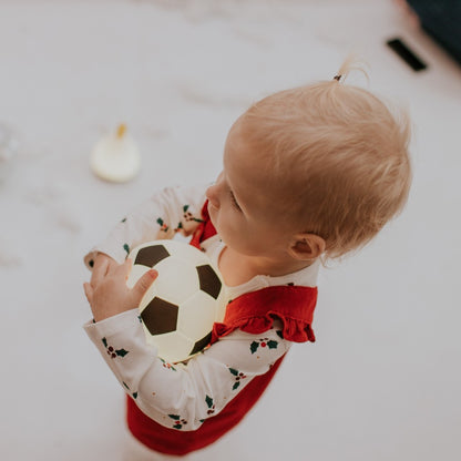 Kleines Kind spielt mit leuchtender Fussball Lampe, warmes LED Licht, erhältlich im Bärechind Winterthur Zürich Schweiz.