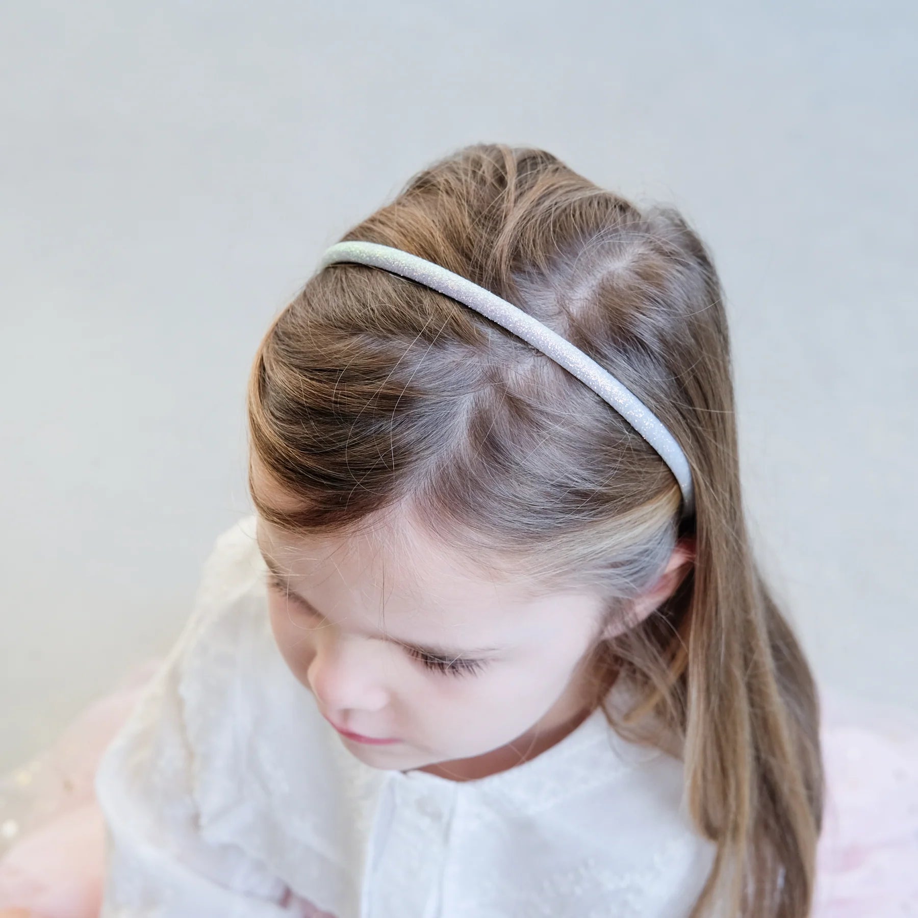 Kind mit glitzerndem Haarreif – funkelndes Haaraccessoire für den Alltag und besondere Anlässe, erhältlich in Winterthur, Zürich, Schweiz.