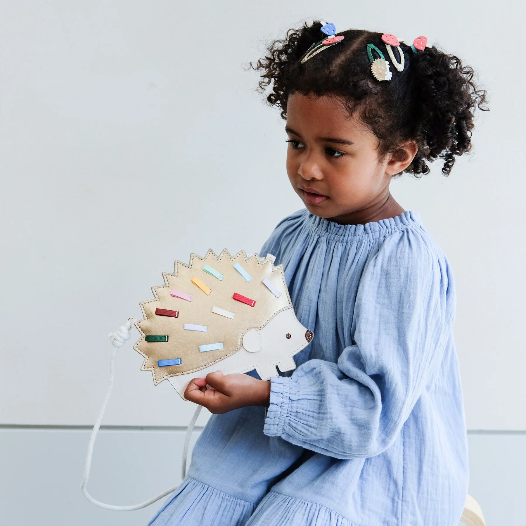 Mädchen trägt Mimi & Lula Igel Tasche Harry mit bunten Details, Kinderaccessoire erhältlich im Bärechind Schweiz.