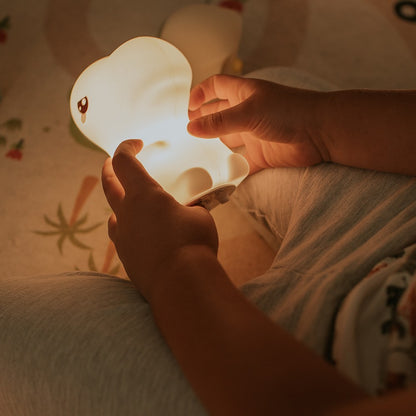 Kind spielt mit leuchtender T-Rex Lampe aus Silikon – warmes Nachtlicht, erhältlich im Bärechind Winterthur Zürich Schweiz.