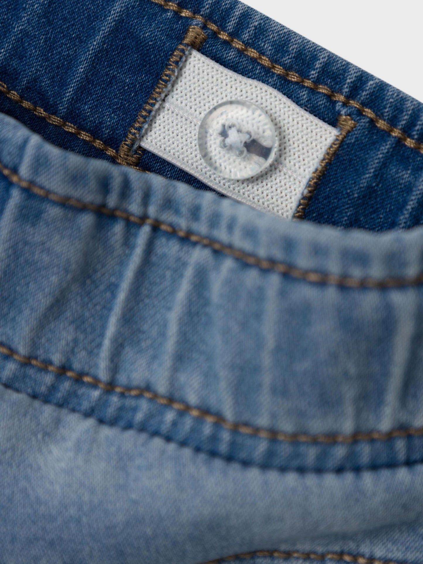  Nahaufnahme des Etiketts und Kordelzugs der Kinder-Jeans

