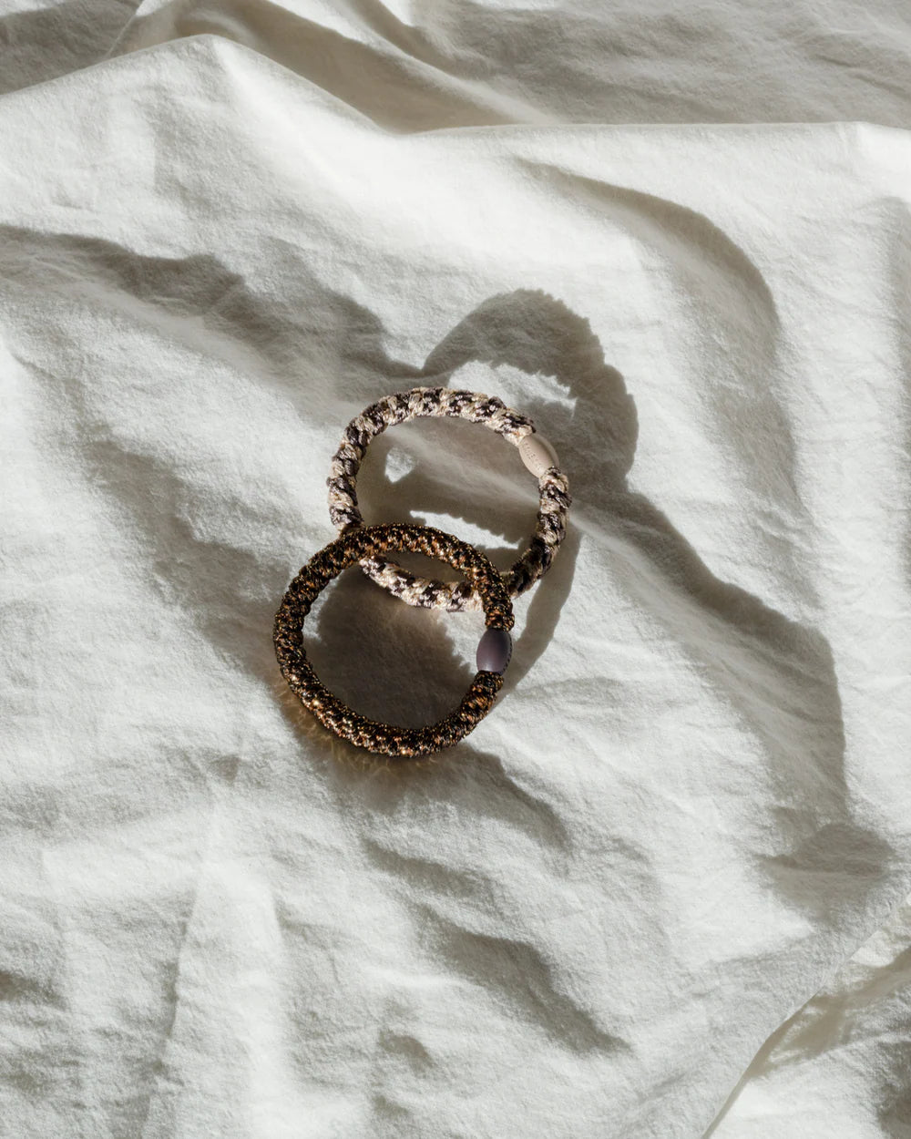 KKNEKKI Haargummi Bronze Glitter als stylisches Accessoire am Handgelenk, erhältlich bei Bärechind.