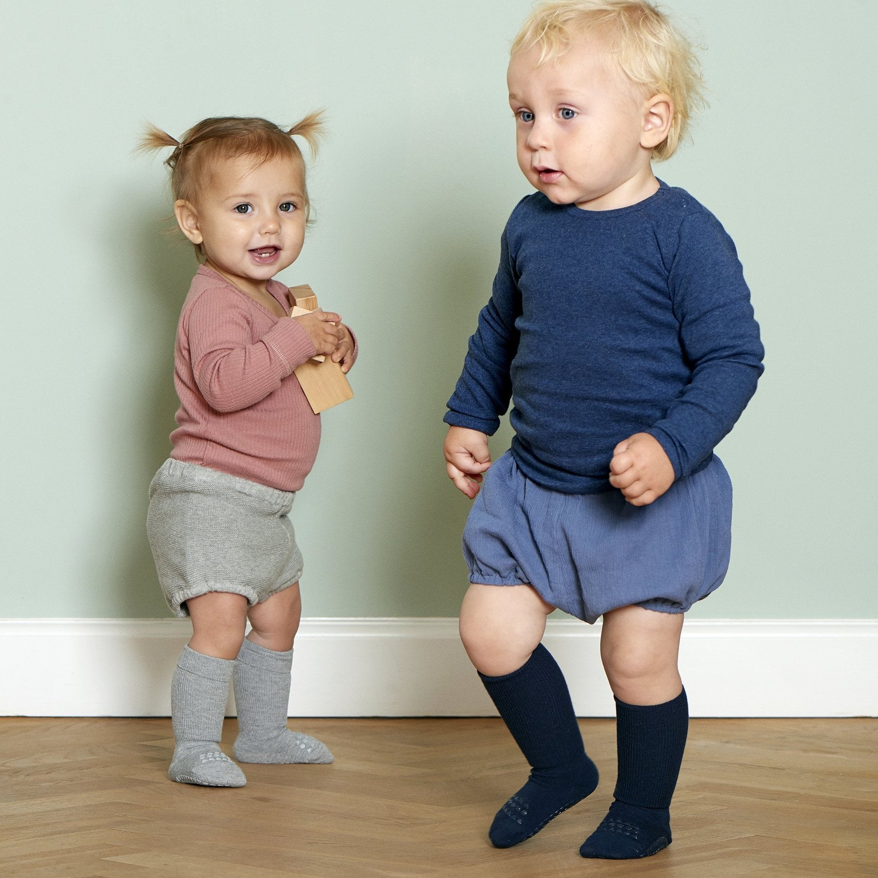 Zwei Kleinkinder mit GoBabyGo Bambussocken Navy mit rutschfester Sohle – perfekt zum Laufenlernen