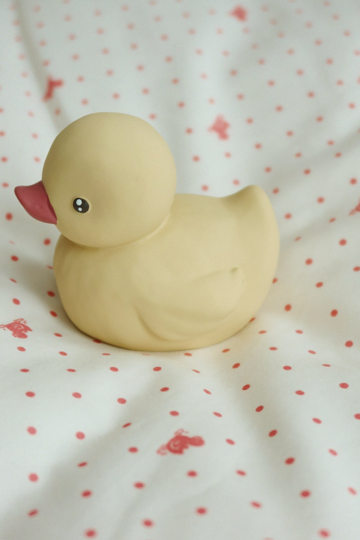 Enten-Badespielzeug auf gepunktetem Stoff