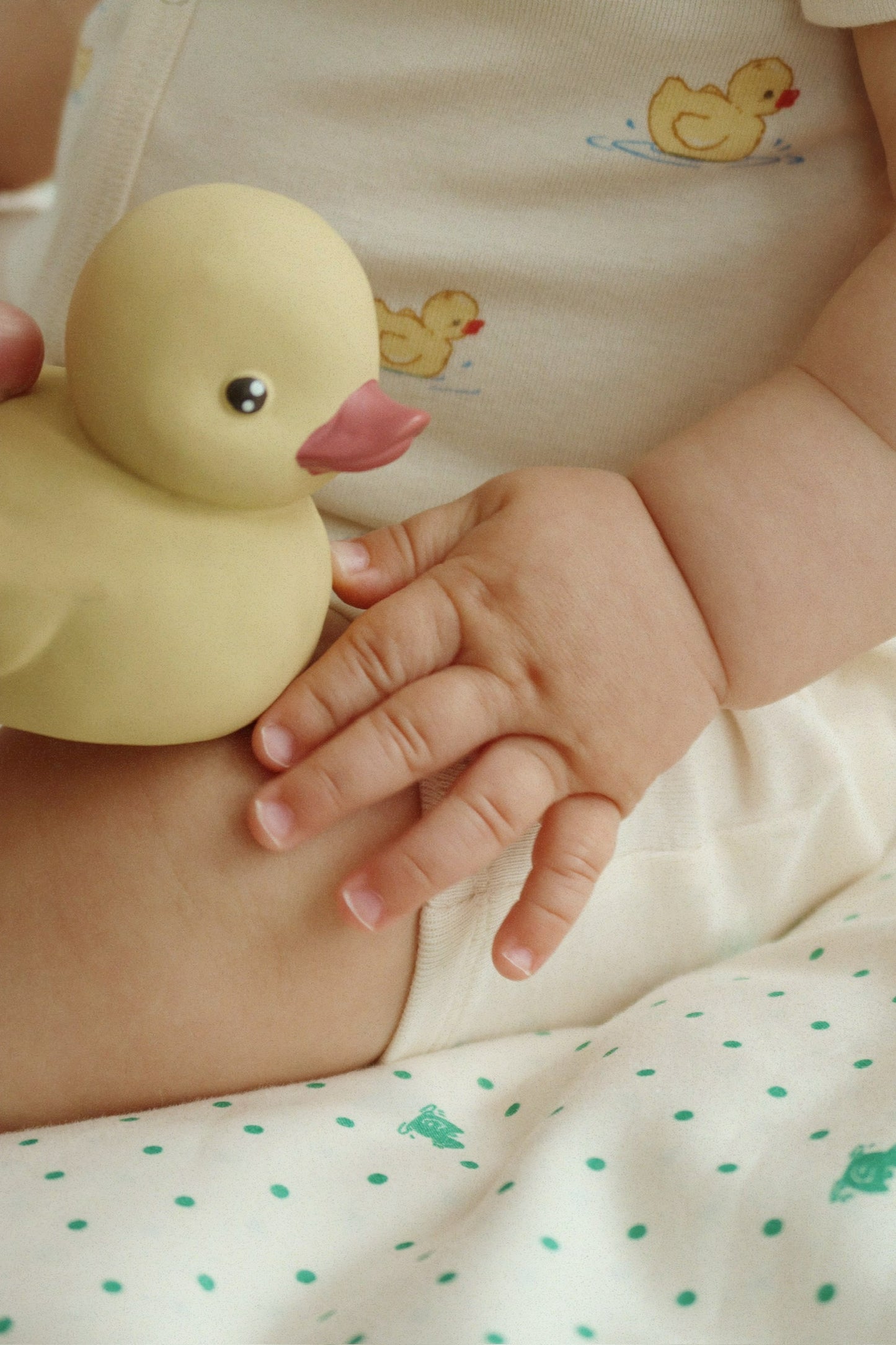 Baby hält das Enten-Badespielzeug in der Hand