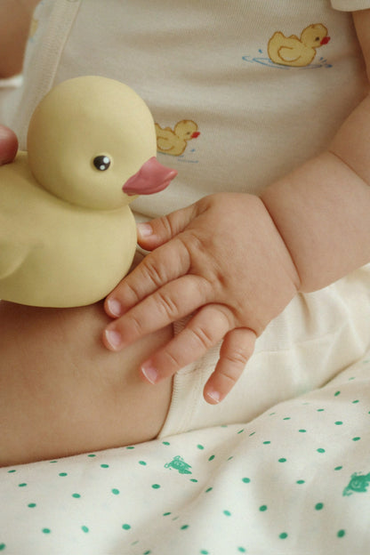 Baby hält das Enten-Badespielzeug in der Hand