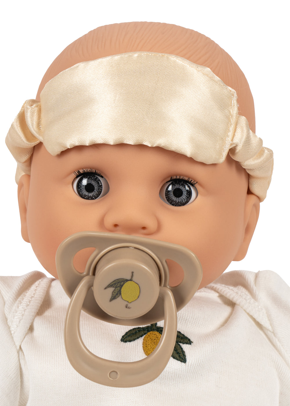 Nahaufnahme des Gesichts der Puppe Lola mit Schnuller