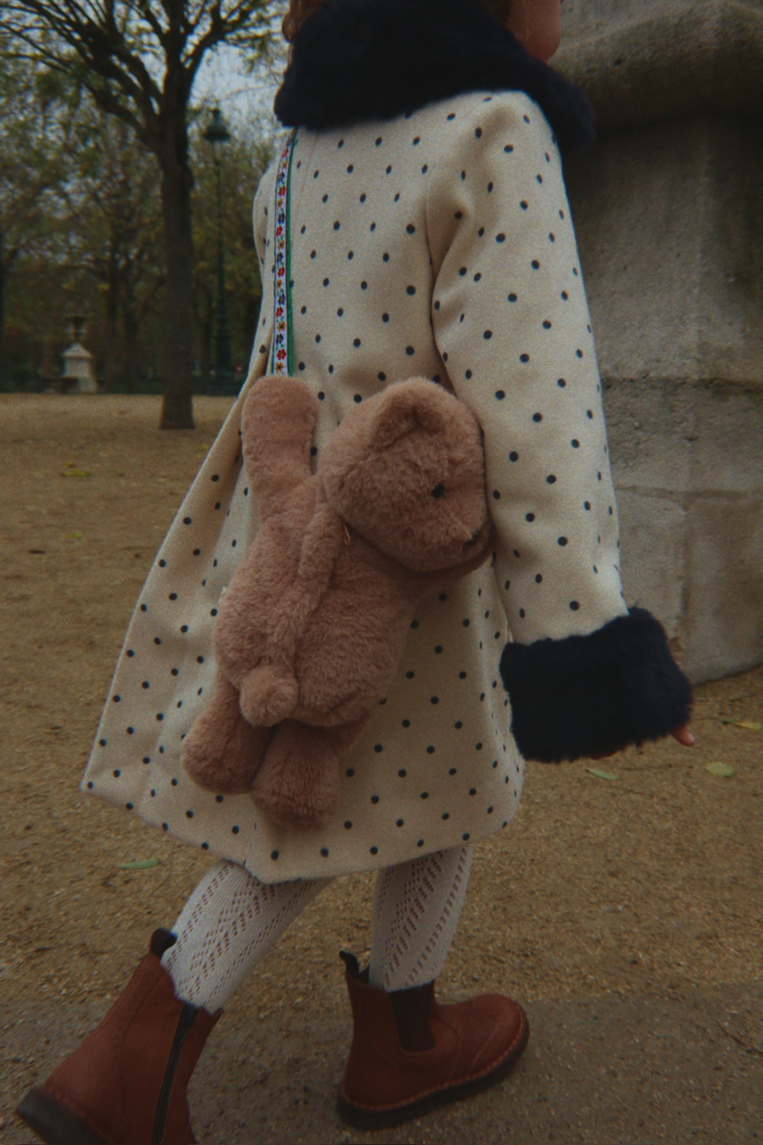Kind trägt die Konges Sløjd Teddy-Tasche beim Spaziergang