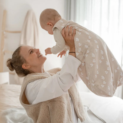 Emma & Noah Kugelschlafsack mit 2.5 TOG in Beige beim Anziehen eines Babys, erhältlich im Bärechind in Winterthur, Zürich, Schweiz.