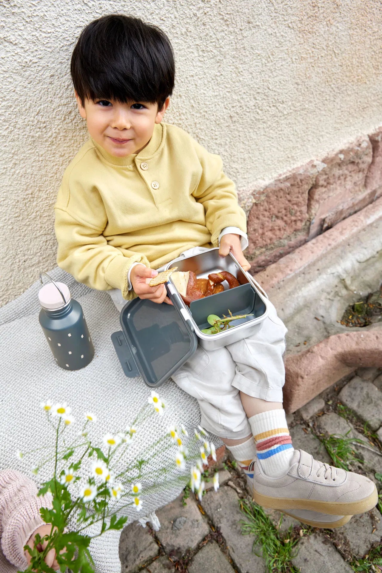 Kind beim Picknick mit der Lässig Edelstahl Znünibox Happy Prints Dunkelblau